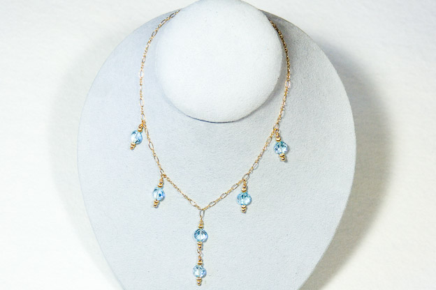 Blue topaz faceted coins on 14k gold chain    $250